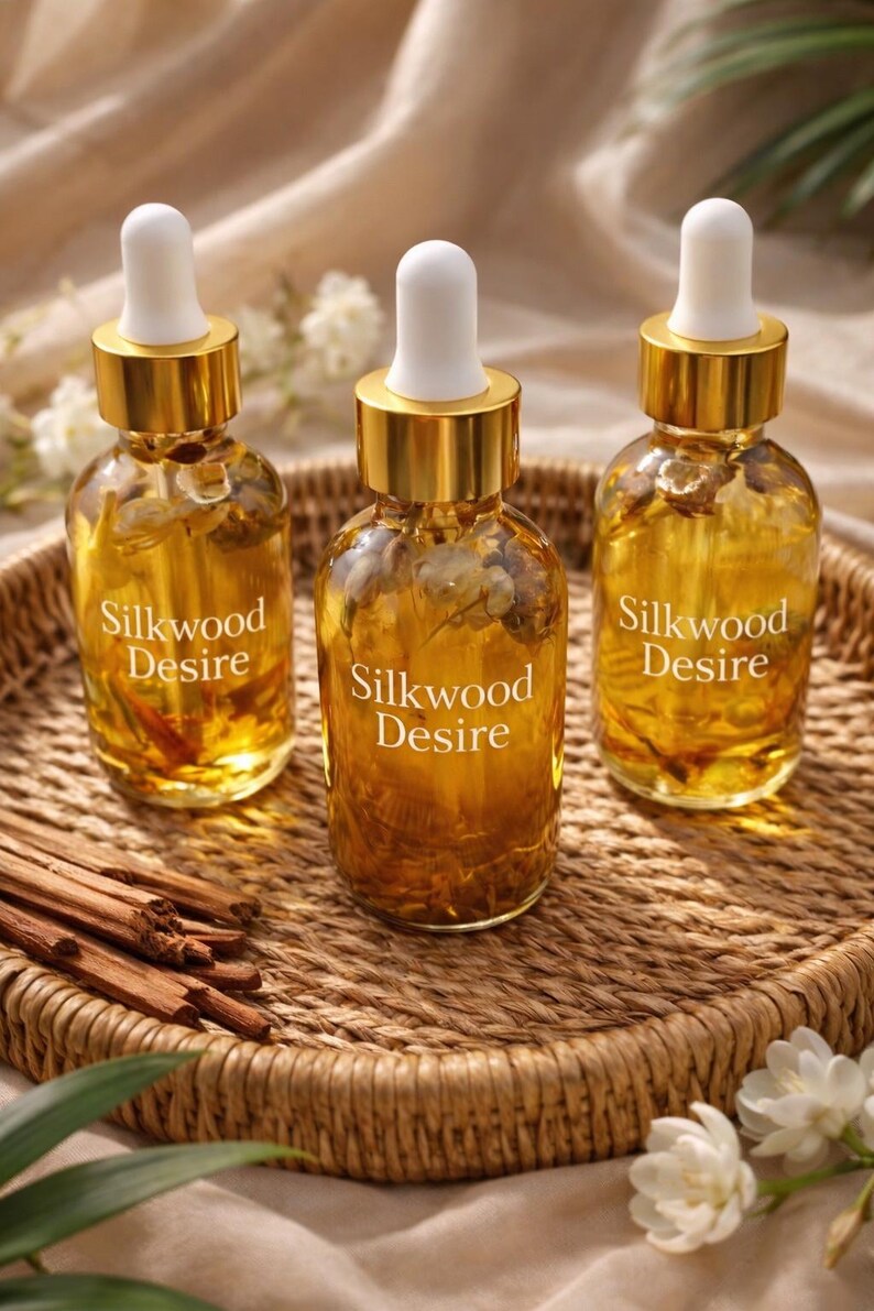 May include: Three glass bottles with gold lids and white droppers, filled with a golden liquid. The bottles are labelled "Silkwood Desire" and sit on a woven tray with cinnamon sticks. The background is a soft, neutral colour.