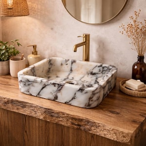 Könnte beinhalten: Handgefertigtes Holzschild mit dem Wort "Welcome" in verspielter Schrift. Das Schild hat einen weißen Hintergrund im Used-Look und einen dunkelbraunen Rand, ideal für eine Eingangstür. Das Schild ist etwa 30 cm breit und 15 cm hoch.