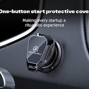 Puede incluir: Una cubierta negra y plateada para el botón de encendido del coche con el logotipo de Mercedes-Benz. La cubierta está instalada en un salpicadero negro. El texto de la imagen dice: "One-button start protective cover. Making every startup a ritualistic experience."