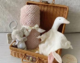 Cesta de presente para bebê em vime neutro com chocalho e manta para enrolar o bebê.
