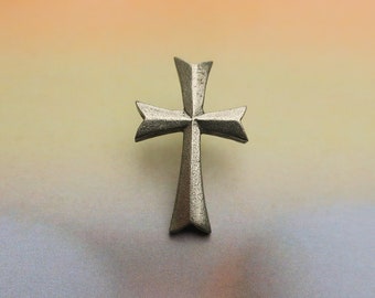 Puede incluir: Un colgante de cruz de plata con un diseño simple y elegante. La cruz está hecha de metal y tiene un acabado liso y pulido.