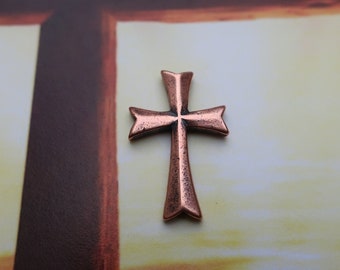 Puede incluir: Una cruz de color cobre con un diseño sencillo, sobre un fondo de cruz de madera.