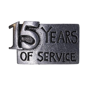 May include: A silver metal pin with the text "15 Years of Service" in black lettering.