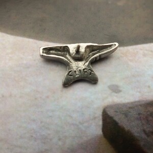 Peut inclure: Un charme miniature en forme d'enclume de couleur argent avec le mot "CLIFF" grav&eacute; sur le dessous.
