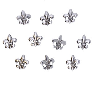 Może przedstawiać: Dziesięć srebrnych zawieszek w kształcie lilii, każda z detalicznym wzorem. Te zawieszki idealnie nadają się do dodania elegancji biżuterii lub rękodziełu.