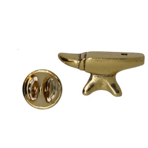 May include: Gold-toned metal pin shaped like an anvil. The pin has a safety clasp on the back.