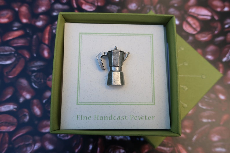 May include: A silver-colored pewter Moka pot in a green box with the text "Fine Handcast Pewter".