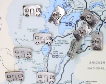 May include: A map of a national park with silver camper van push pins. The pins are scattered across the map, with some clustered together. The map shows the names of lakes and other geographical features.