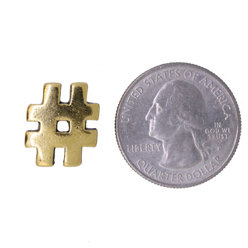 May include: A gold-colored metal hashtag symbol charm, about the size of a US quarter.