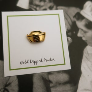 May include: Gold-dipped pewter nurse's hat pin. The pin is on a white card with green trim and the text "Gold Dipped Pewter".