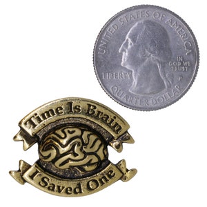 May include: Gold-toned metal pin with a brain design and the text "Time Is Brain I Saved One" on two banners.