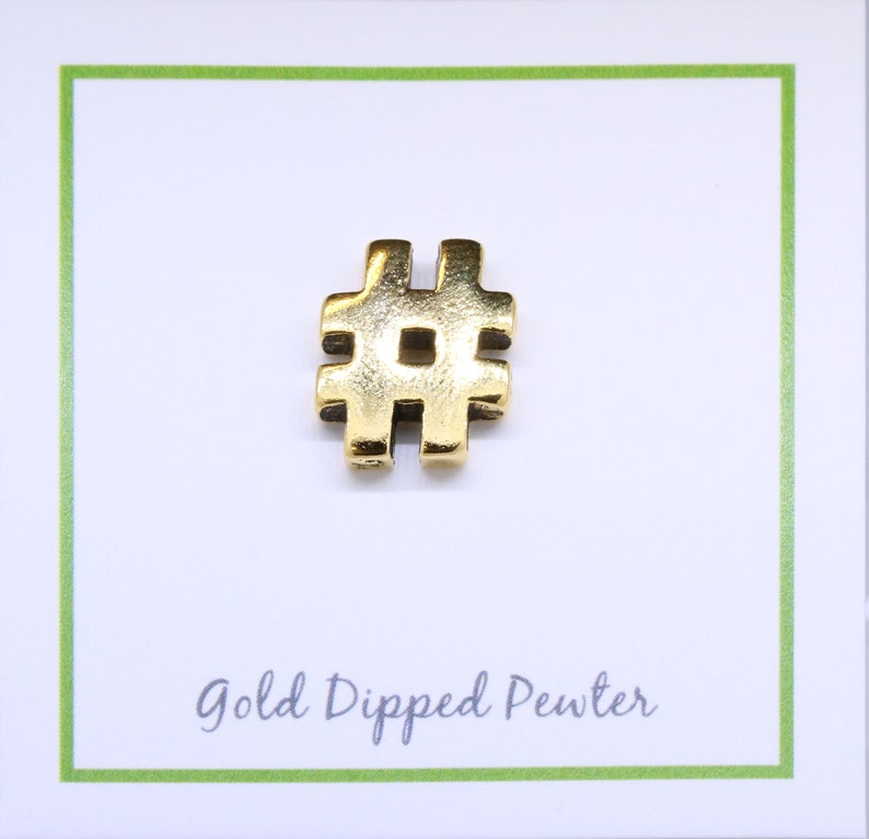 May include: Gold-dipped pewter charm in the shape of a hashtag symbol. The charm is on a white card with the text "Gold Dipped Pewter".