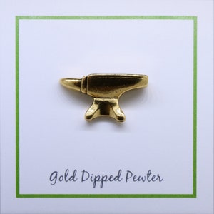 May include: A gold-dipped pewter anvil pin. The pin is a miniature replica of a traditional blacksmith's anvil.
