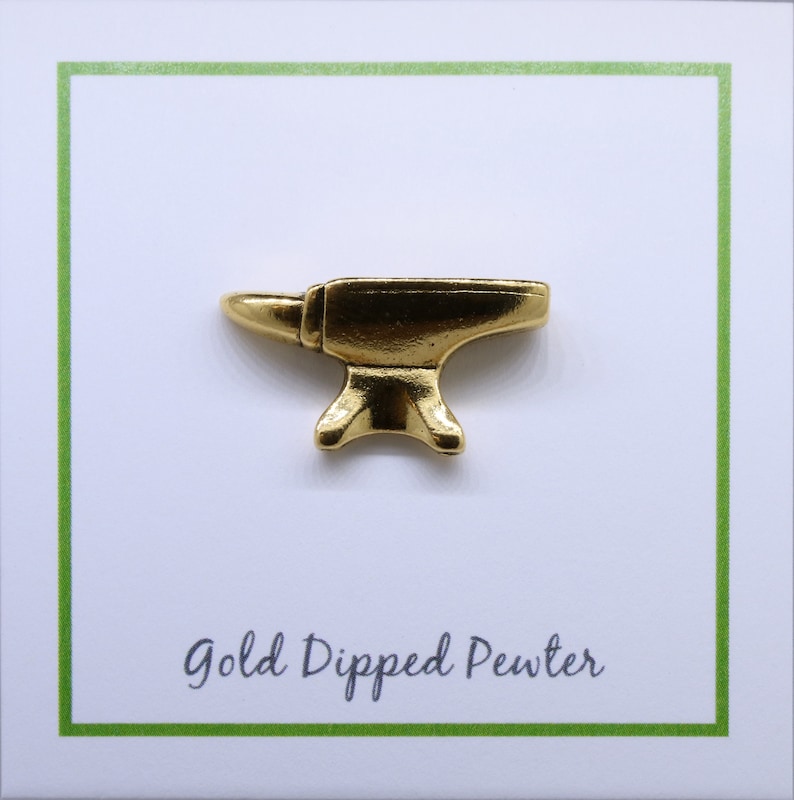 May include: A gold-dipped pewter anvil pin. The pin is a miniature replica of a traditional blacksmith's anvil.