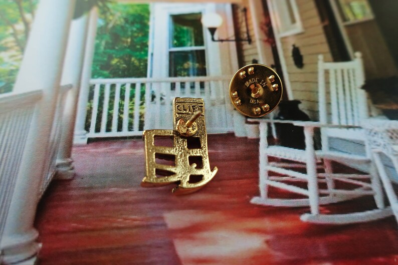 Pode incluir: Pin de metal dourado com um design de cadeira de balan&ccedil;o com a palavra "CLIFT" no verso. O pin &eacute; feito nos Estados Unidos.