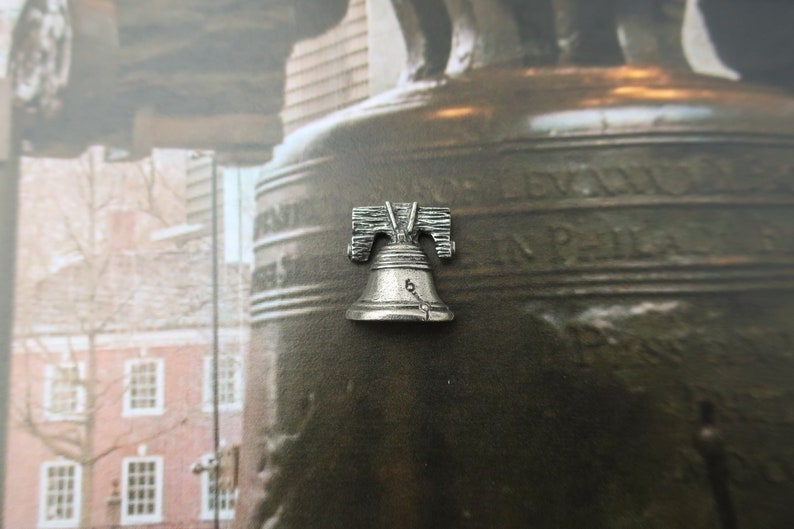 Puede incluir: Una r&eacute;plica de plata de la Campana de la Libertad, un famoso monumento de Filadelfia, Pensilvania. La campana est&aacute; inscrita con "Proclaim Liberty Throughout All The Land" y "In Philadelphia Pass And Stow" en el lateral.
