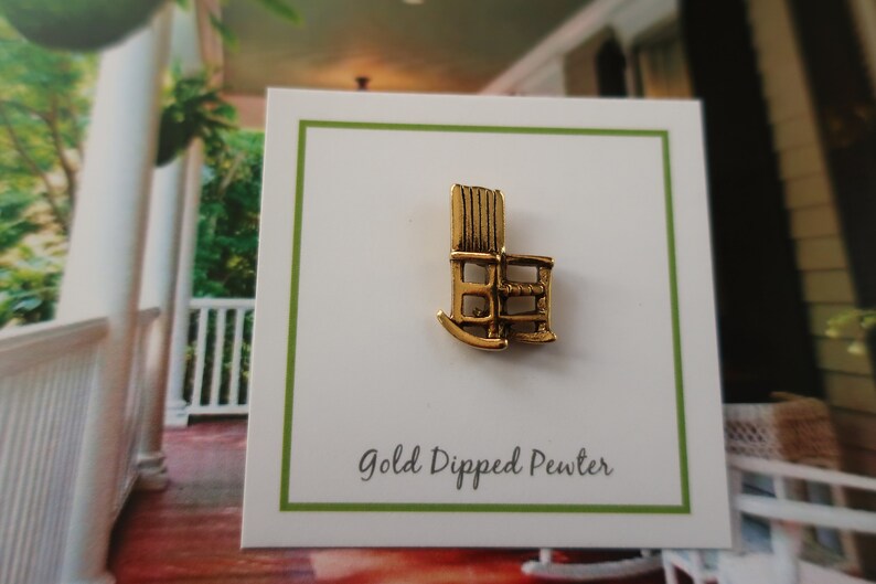Pode incluir: Encanto de cadeira de balan&ccedil;o de peltre banhado a ouro. O encanto &eacute; uma pequena r&eacute;plica detalhada de uma cadeira de balan&ccedil;o. O encanto est&aacute; em um cart&atilde;o branco com o texto "Gold Dipped Pewter".