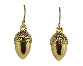 May include: A pair of gold acorn dangle earrings. The acorns are detailed with a textured surface and have a shiny finish.