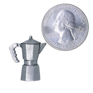 May include: A silver-colored miniature espresso maker, about the size of a US quarter.