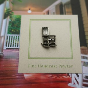 Pode incluir: Um amuleto de cadeira de balan&ccedil;o de peltre prateado com o texto "Fine Handcast Pewter" em um cart&atilde;o.