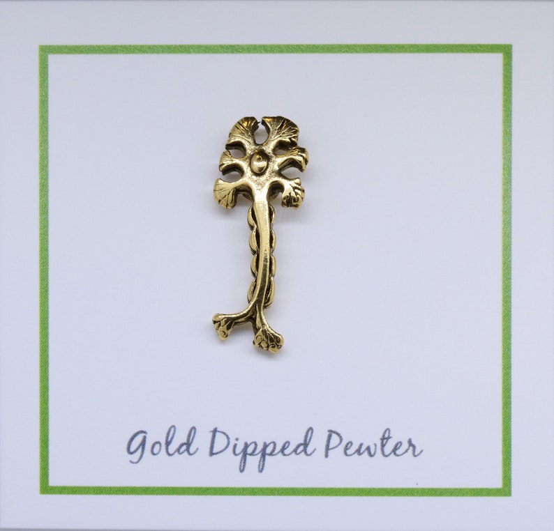 May include: Gold dipped pewter charm in the shape of a stylized tree with a single trunk and multiple branches. The charm is on a white card with green border and the text "Gold Dipped Pewter".