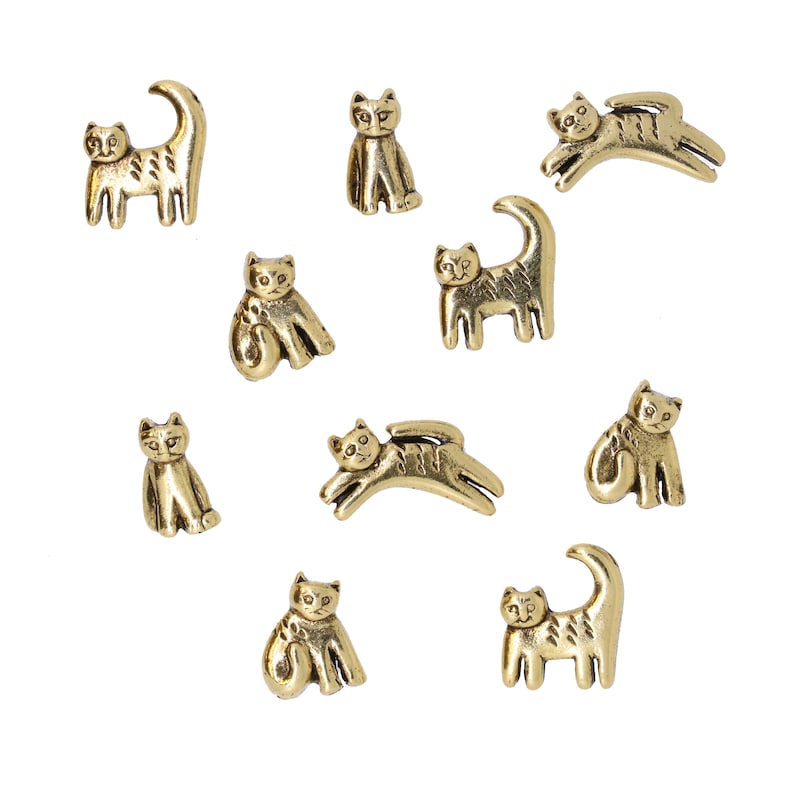 May include: A set of ten gold-toned metal cat buttons. The buttons are all different designs, some are sitting, some are standing, and some are jumping.