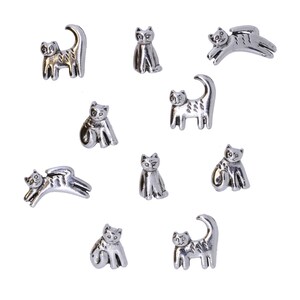 May include: A set of ten silver cat figurines in various poses. The cats are all in a sitting or lying down position, and they have different facial expressions.