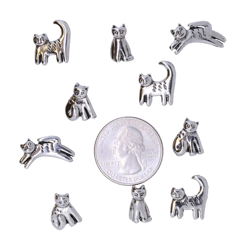 May include: Ten silver cat figurines of varying poses, including sitting, lying down, and standing. The figurines are approximately the size of a US quarter.