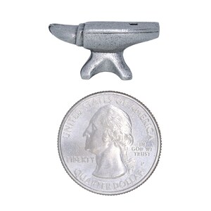 Peut inclure: Une petite enclume en argent, de la taille d'une pi&egrave;ce de 25 cents am&eacute;ricaine.