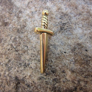 May include: A gold-colored dagger pendant with a twisted design on the handle.