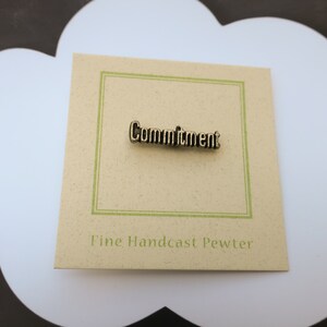 May include: A brown card with a green border and the word "Commitment" in gold lettering. The card also says "Fine Handcast Pewter".