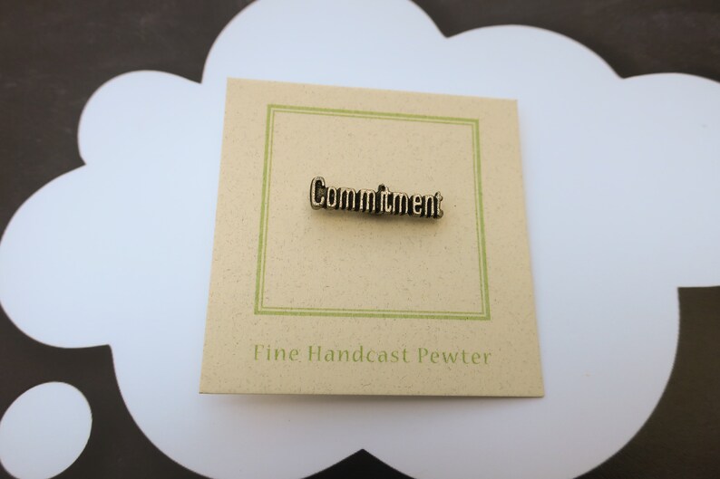 May include: A brown card with a green border and the word "Commitment" in gold lettering. The card also says "Fine Handcast Pewter".