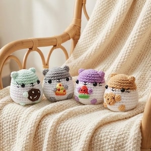 Puede incluir: Cuatro juguetes de hámster hechos a mano en una fila, cada uno con un esquema de color y un alimento diferente. Los hámsteres son blancos con detalles grises, verdes, morados y marrones. Uno sostiene una galleta, otro una porción de pizza y un tercero una sandía.