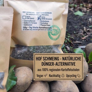 May include: A package of natural fertilizer made from potato peels. The package has text in German, including "HOF SCHMEING - NATÜRLICHE DÜNGER-ALTERNATIVE" and details about the product's use for various plants. The package is sitting on top of potatoes.