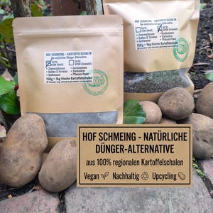 May include: Two brown paper bags of Hof Schmeing natural fertilizer alternative made from potato peels, with text in German. A sign reads "Hof Schmeing - Natural Fertilizer Alternative" with the words "Vegan", "Sustainable", and "Upcycling". Potatoes are in the foreground.
