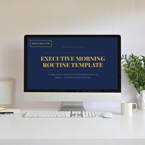 May include: A desktop computer displays a navy blue screen with gold text: "EXECUTIVE MORNING ROUTINE TEMPLATE." The text "PRINTABLE PDF" is in the top left corner. A keyboard, mouse, and mug sit on the white desk.