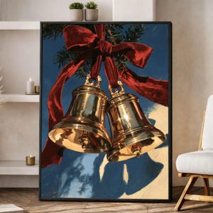 May include: A framed wall art print featuring two polished gold-coloured bells hanging from a large, vibrant red ribbon. The bells are suspended against a deep blue background with a soft, light-coloured shadow cast below them, creating a festive scene.