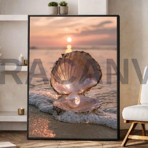 Op de afbeelding: Een ingelijste kunstdruk met een geopende schelp met daarin een grote, iriserende witte parel, rustend op een zandstrand bij zonsondergang. De achtergrond toont een kalme oceaan met zachte golven en een gloeiende zon aan de horizon in warme tinten.