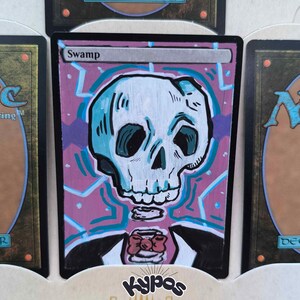 Könnte beinhalten: Angepasste Magic: The Gathering-Karte mit einem handgezeichneten Schädeldesign. Die Karte hat einen lila Hintergrund mit einem geometrischen Muster und dem Wort "Swamp" oben. Der Schädel ist weiß und blau, mit einem schwarzen Anzug und einer Fliege.