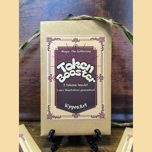 Könnte beinhalten: Ein rechteckiger Umschlag aus braunem Papier mit einem Etikett, das den Text Magic: The Gathering Token Booster, 5 Tokens Inside!, 1 rare illustration guaranteed und KyposArt enthält. Das Etikett hat eine dunkelviolette Mitte und dekorative Ränder.