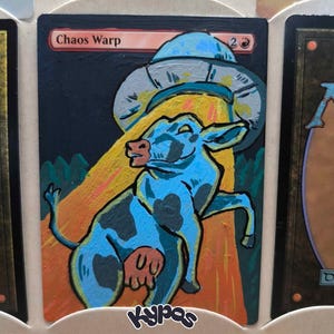 May include: A custom-painted Magic: The Gathering card featuring a blue cow being abducted by a UFO. The card is titled "Chaos Warp" and has a black background with orange and yellow beams of light. The artist's signature is in the bottom right corner.