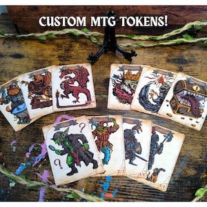 Könnte beinhalten: Eine Sammlung rechteckiger Spielkarten mit farbenfrohen Illustrationen von Fantasy-Kreaturen und Gegenständen, darunter ein Drache, eine Schatztruhe und ein Goblin. Der Text CUSTOM MTG TOKENS! steht oben. Jede Karte hat einen hellbraunen Hintergrund.