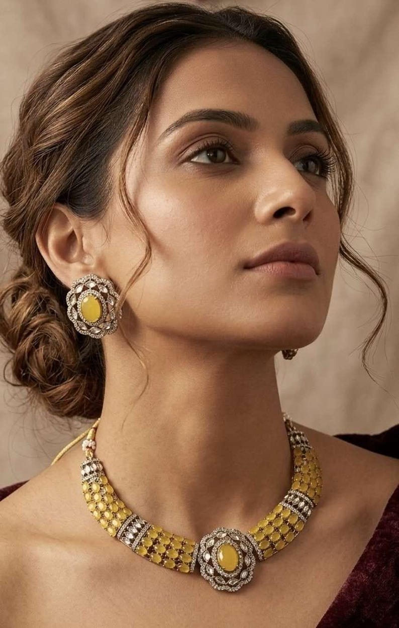 May include: A jewelry set consisting of a necklace and matching stud earrings. The necklace features multiple rows of oval yellow stones accented by small clear stones, with a central floral-shaped pendant. The earrings mirror the floral design.