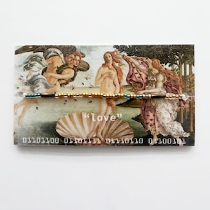 May include: A beaded bracelet featuring metallic gold, bronze, and teal beads, displayed on a rectangular card printed with a reproduction of The Birth of Venus painting, the word "love", and binary code text at the bottom edge.
