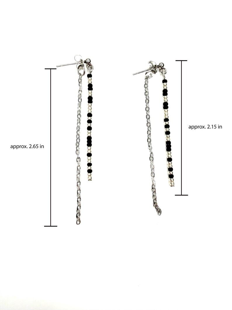May include: A pair of silver-toned dangle earrings. Each earring features a post with a small cluster of beads, a chain, and a strand of black beads. The earrings are approximately 2.65 inches and 2.15 inches long.