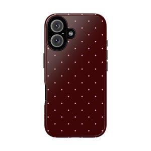 May include: A burgundy phone case with a repeating pattern of small, light pink polka dots. The case has a camera cutout with two lenses and a flash. The case is designed to fit a smartphone.