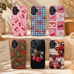 May include: A collection of phone cases with cherry designs. The cases feature various patterns, including pink with cherries, blue gingham with bows, and leopard print. Other cases have a black background with cherries and a bow.