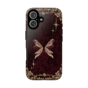 May include: A smartphone case with a burgundy background featuring a butterfly design. The case has a gold ornate border and gold star accents. The camera lenses are visible at the top.