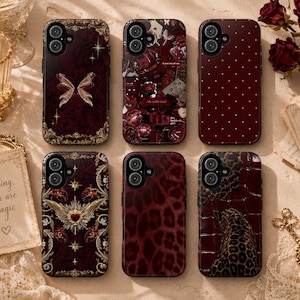 May include: A collection of six phone cases with various designs. The cases feature a deep burgundy color with patterns including a butterfly, floral collage, polka dots, leopard print, and a heart with wings. The cases are arranged on a light-colored surface.