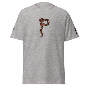 May include: A grey t-shirt with a snake design in brown, orange, and black. The snake is coiled and has a long, curved body. The shirt has short sleeves and a crew neck.